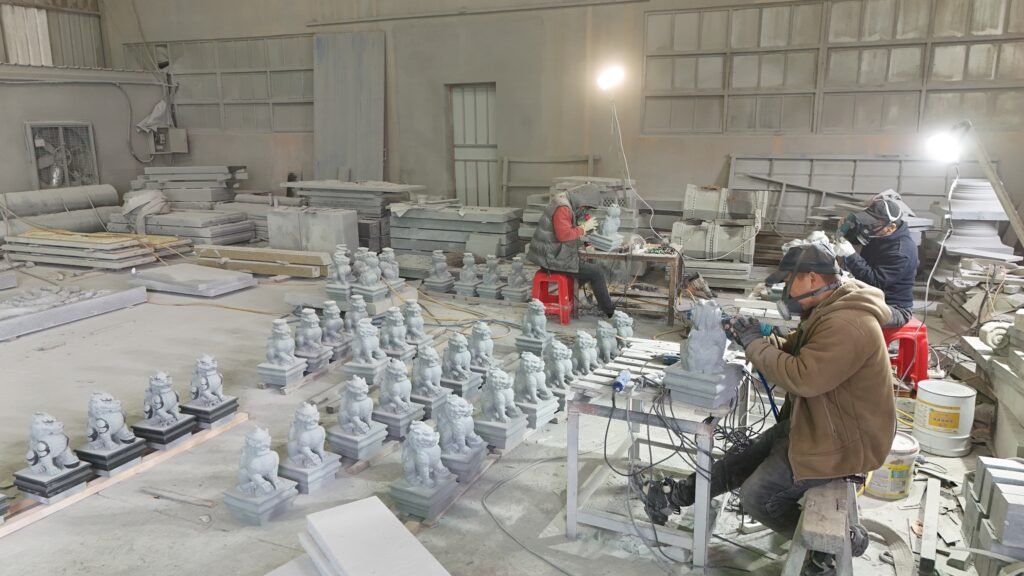 Master craftsmen performing intricate Custom Stone Carving on high-quality granite at HuaFa Stone.