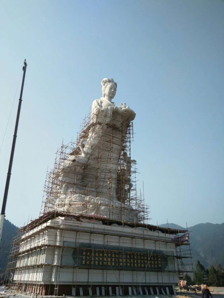 Large hand-carved stone statue installation on-site by Huafa Stone for a traditional temple architecture project.